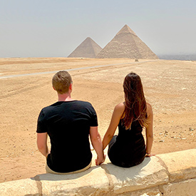 Couple sitting at the pyramids in Egypt