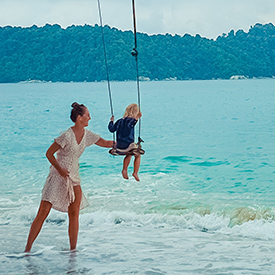 Mother pushing child at beach