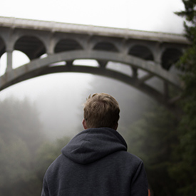 Guy looking at bridge near Oregon Coast