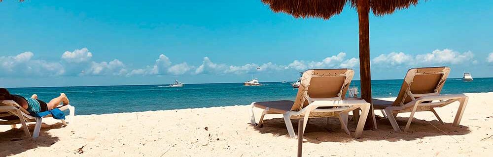 Cozumel beach with sun chairs and boats